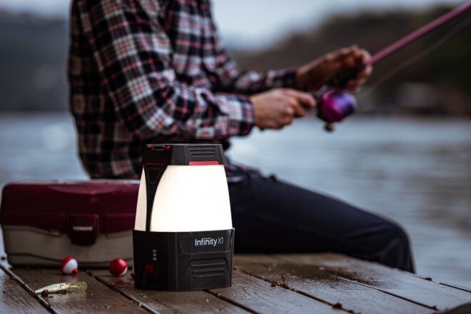 A lamp sitting beside someone fishing on a port
