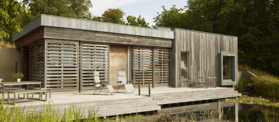 The front porch of a home has two outdoor seats