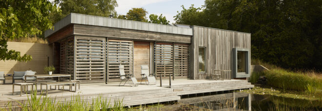 The front porch of a home has two outdoor seats