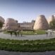 Curving garden in front of a modern building flanked by large earth cone-like forms