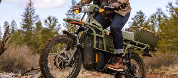 The bottom half of a person riding on an electric bike