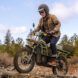 A man wearing a helmet and riding an electric bike through a rocky terrain