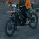 The bottom half of a person riding on an electric bike