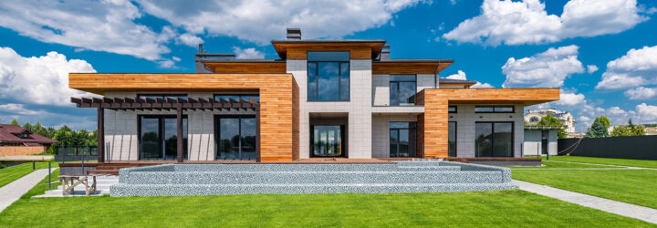 A two-story wooden sprawl of a home with a green front lawn