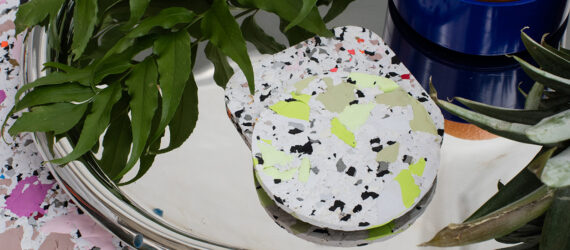 Two coasters on a silver tray over a mat