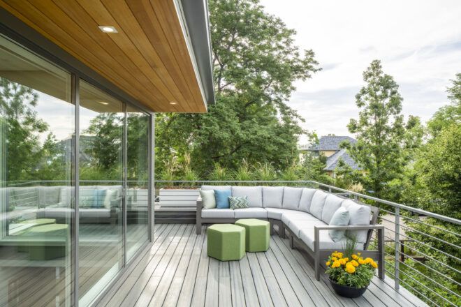 Terrace on the upper level that wraps around a corner. Features a corner couch and green hexagonal coffee tables