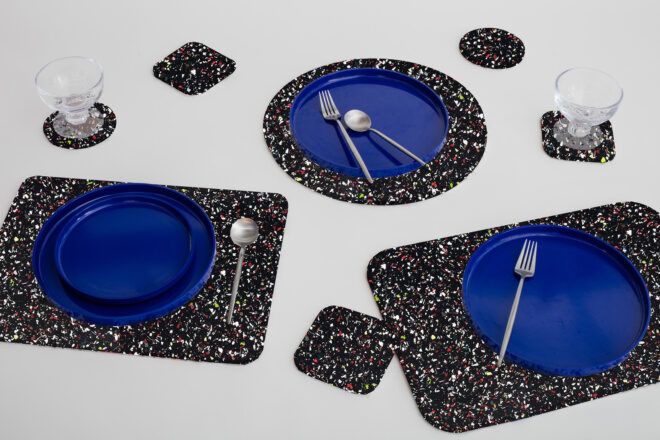 A variety of placemats and coasters with plates and utensils and cups on top of them