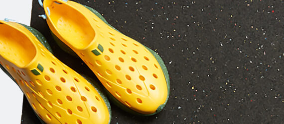 Two yellow shoes with holes and a black mat
