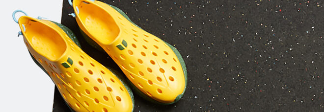 Two yellow shoes with holes and a black mat