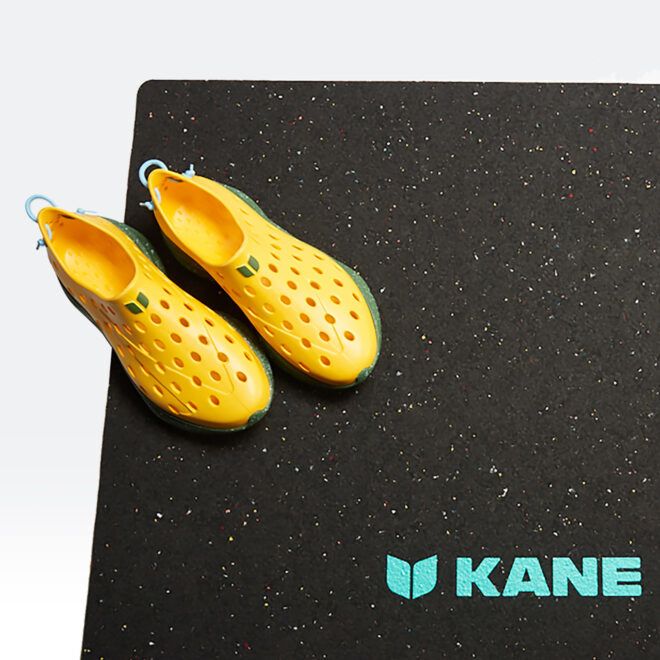 Yellow shoes with holes on a black mat