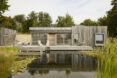 A wooden home with a lake in the front yard