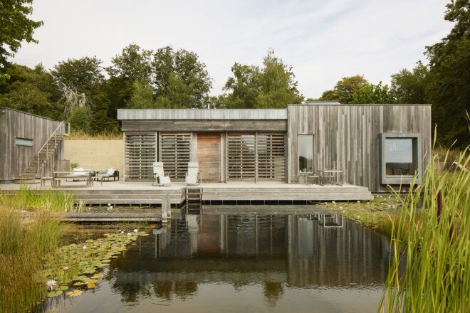 A wooden home with a lake in the front yard