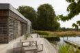 The front porch of a home with an outdoor seating overlooking a lake