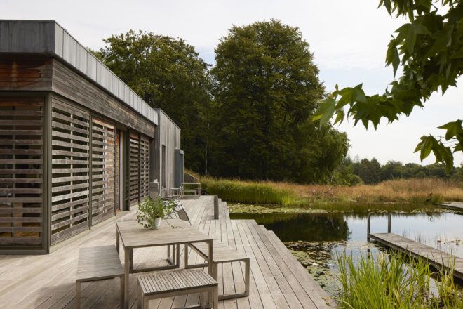 The front porch of a home with an outdoor seating overlooking a lake