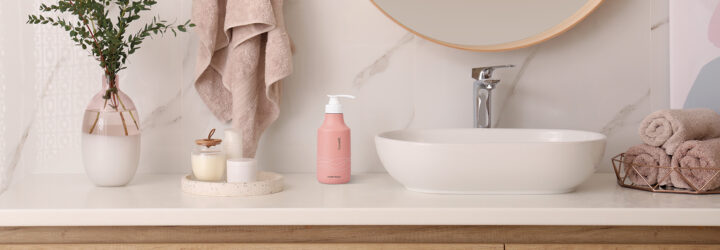 Vase with beautiful branches and fresh towels near vessel sink in bathroom. Interior design