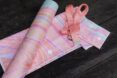 A variety of pink yoga mat and straps laid on top of each other