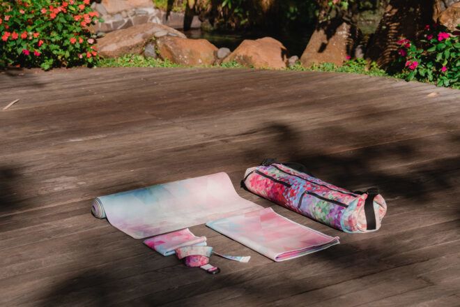 A variety of yoga products laid out on a wooden deck