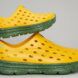 Two yellow shoes with holes and green insoles