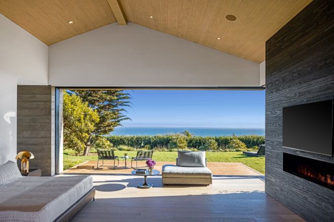 An open wall connecting to an outdoor seating area to the bedroom