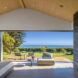 An open wall connecting to an outdoor seating area to the bedroom