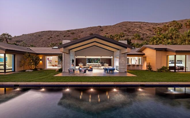 A stretch of a home behind a river in front of it