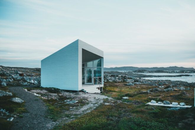 A square tiny home in the middle of a wet plains