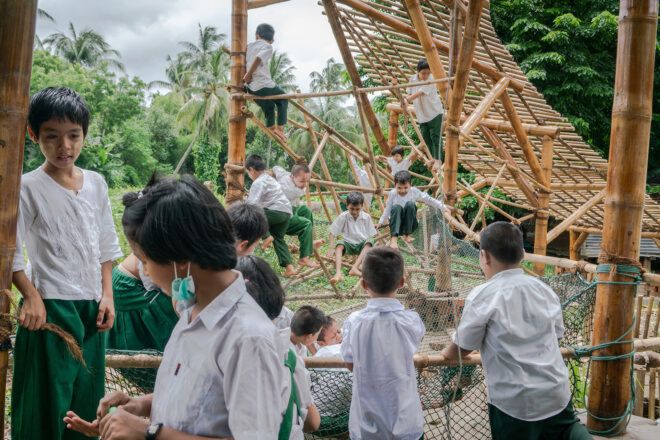 An exposed interlacing wooden beams filled with children playing all around and within it