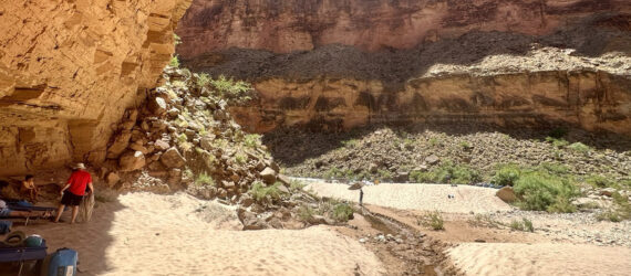 People resting underneath the shade of a canyon