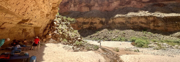 People resting underneath the shade of a canyon