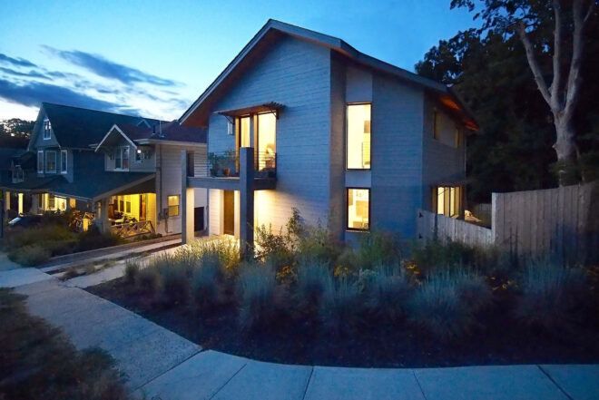 At night a two-story home brightly lit from within