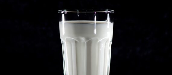A glass of milk against a black background