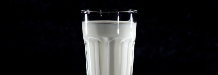 A glass of milk against a black background