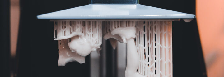 An up-close of a 3D printing that looks like strands of white coming down from a machine