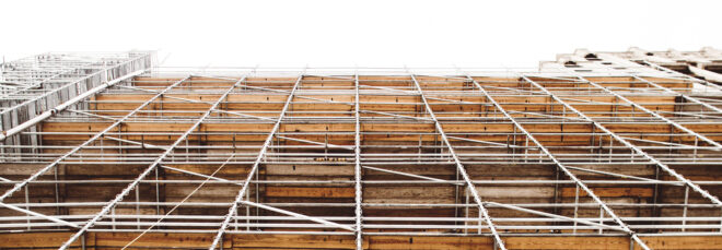 An up-close shot of wooden slats and metal poles of an under construction building