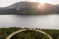 A rounded pathway that overlooks a lake and mountain scenery
