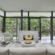 A firepit and living room space that faces glass walls